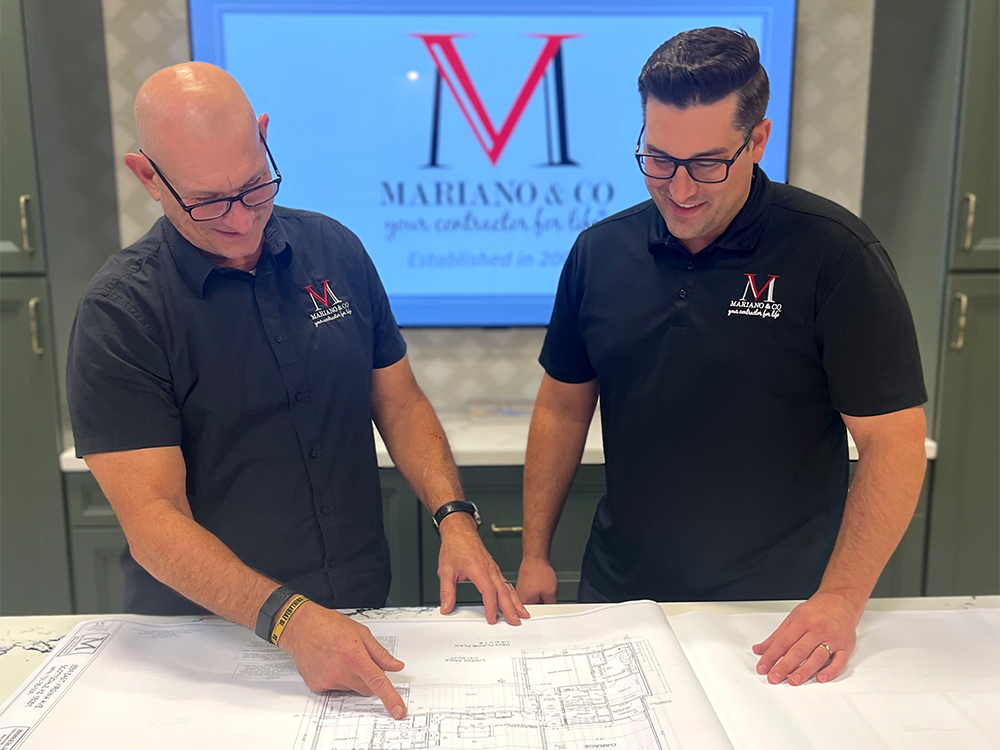 Vic and Lucien Mariano reviewing a set of floor plans at the design center